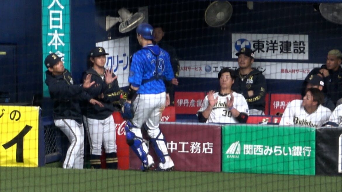 ファールフライを追いかけてきた伊藤捕手がベンチに落ちないよう制止する石川亮