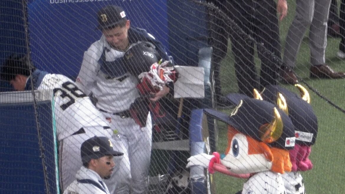 たくさんの野球道具を両手に抱えてベンチを後にする紅林