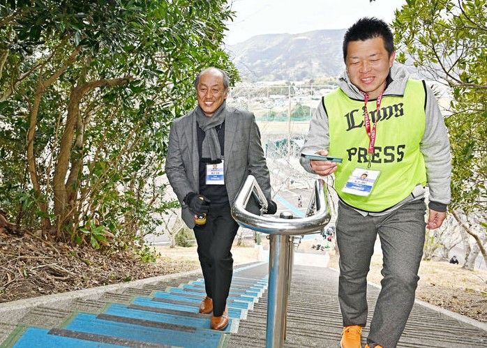 金子真仁記者(右)と一緒に南郷キャンプ名物の長い階段を上る渡辺久信氏