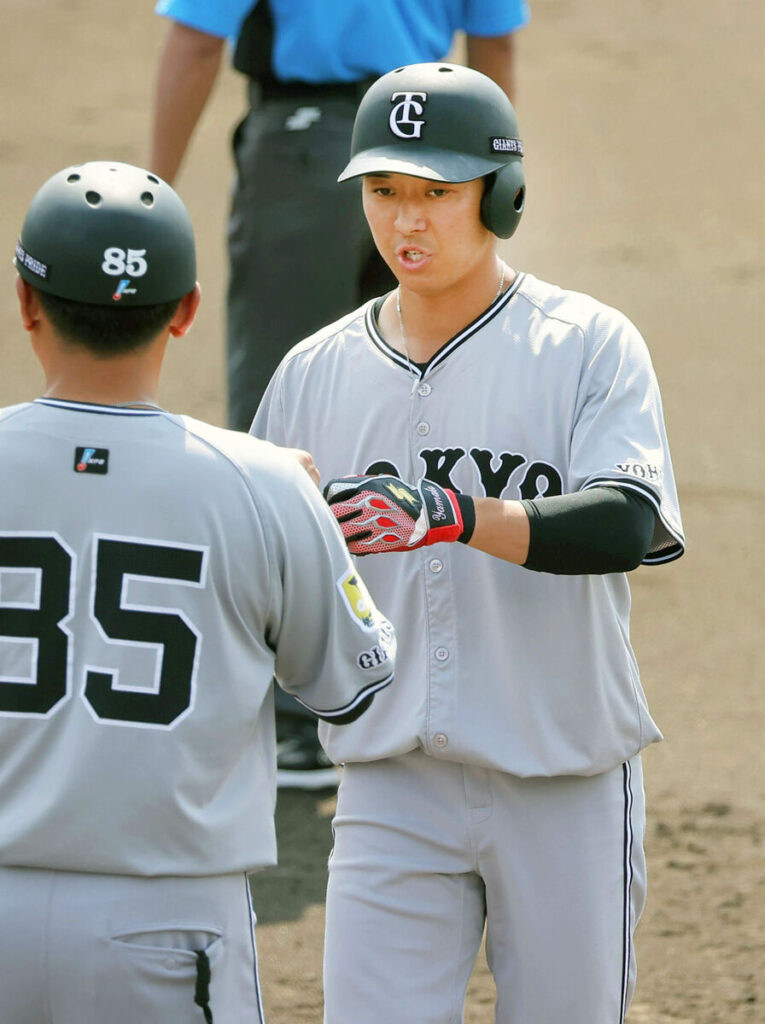 ５回、安打を放ち、一塁コーチとタッチを交わす鈴木大（カメラ・小泉　洋樹）