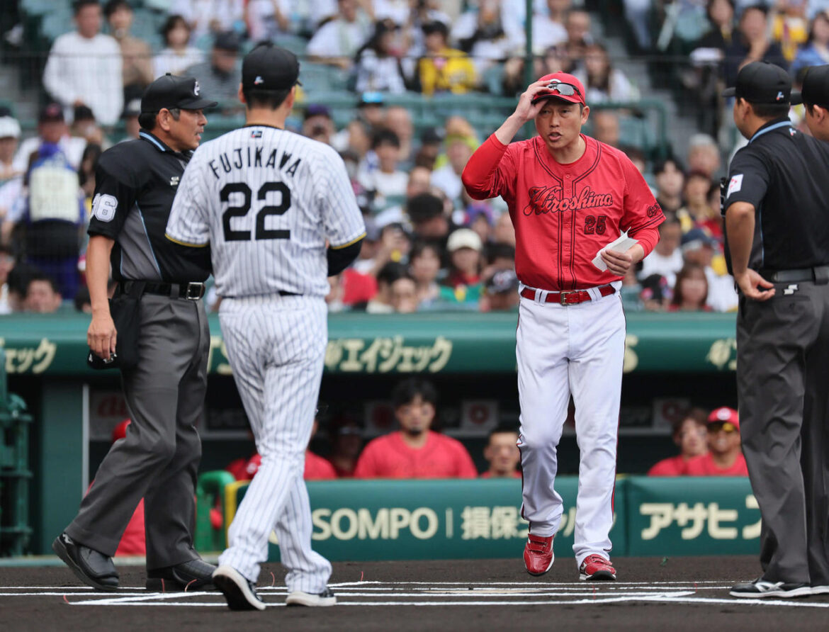 阪神対広島　メンバー確認で目を合わせ、あいさつと握手を交わした阪神藤川監督（左）と広島新井監督（撮影・宮崎幸一）