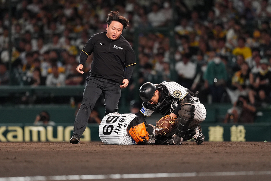打球を受けて倒れ込む阪神・石井大智【写真：小林靖】