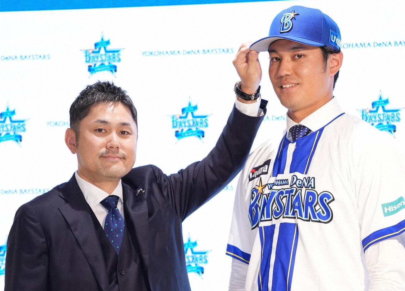 DeNA入団会見後、チーム統括本部萩原龍大本部長から帽子を被せてもらう