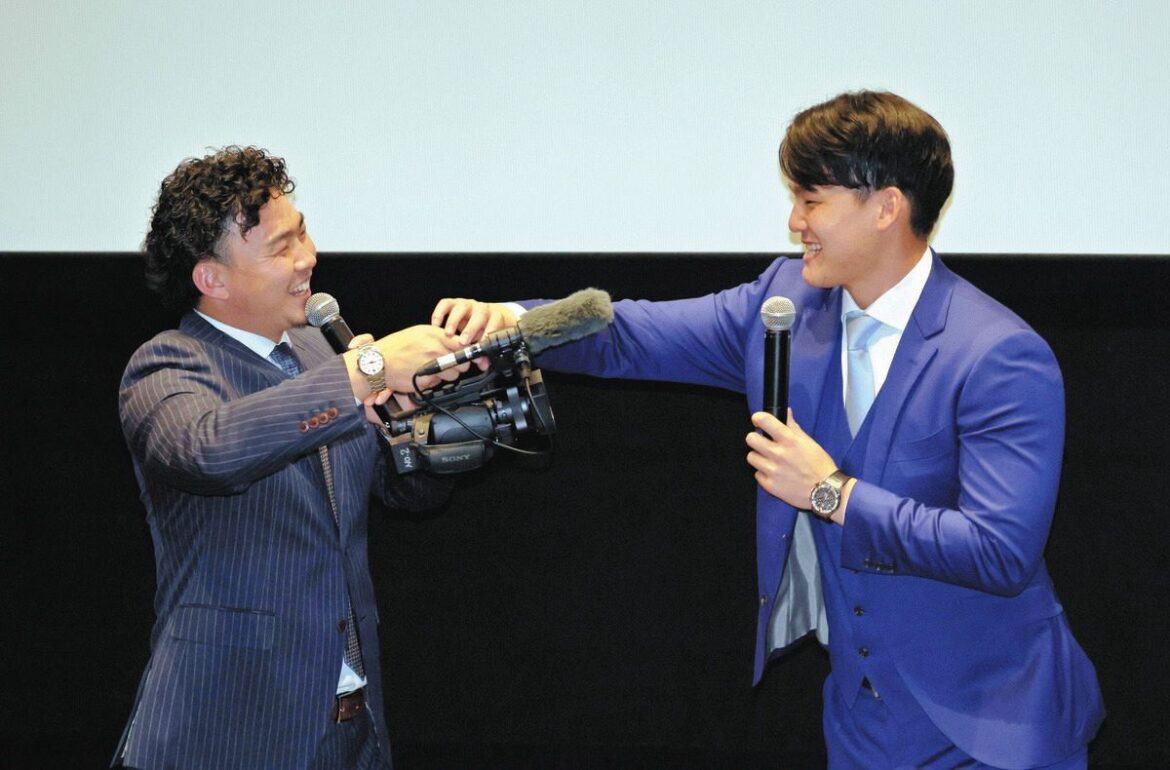 上映後のトークショーで、カメラを構え石川昂（右）をインタビューする小笠原