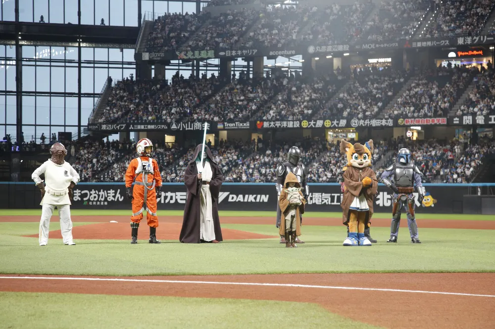 キャラクターたちに見守られながらファーストピッチを行う永尾柚乃