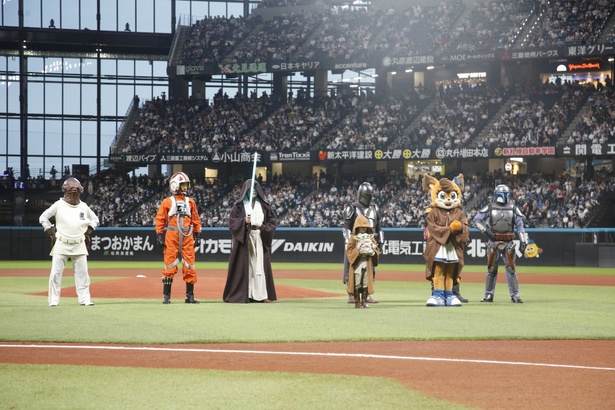 キャラクターたちに見守られながらファーストピッチを行う永尾柚乃