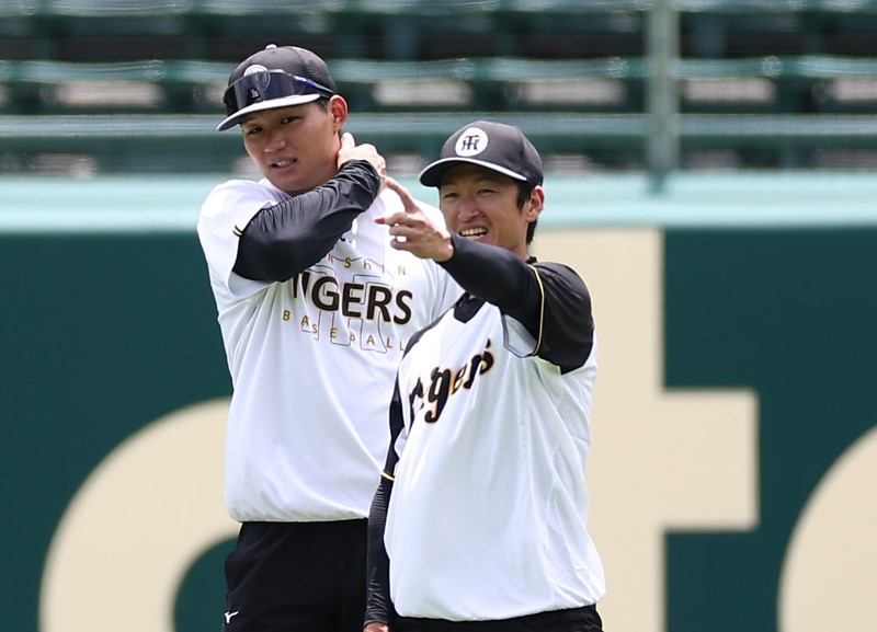 試合前の外野守備練習でで森下(左)と話をする近本