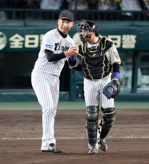 阪神対DeNA DeNAに勝利し岩崎（左）は笑顔で梅野と握手する（撮影・加藤哉）