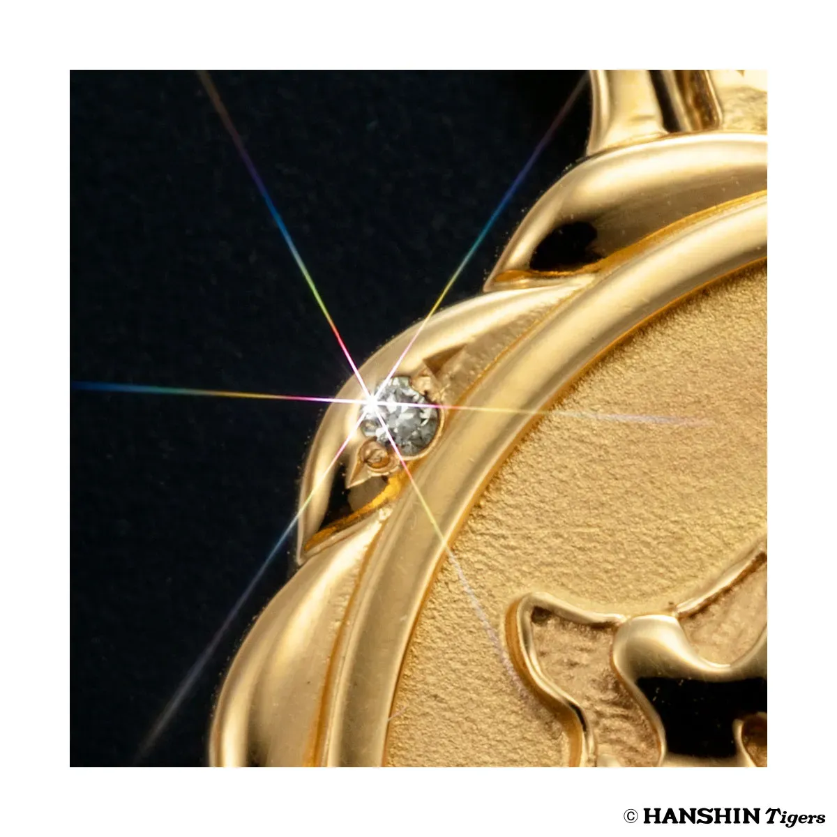 金色の装飾品の一部を拡大した写真で、ダイヤモンドが埋め込まれている。光の反射が美しく、高級感を演出している。