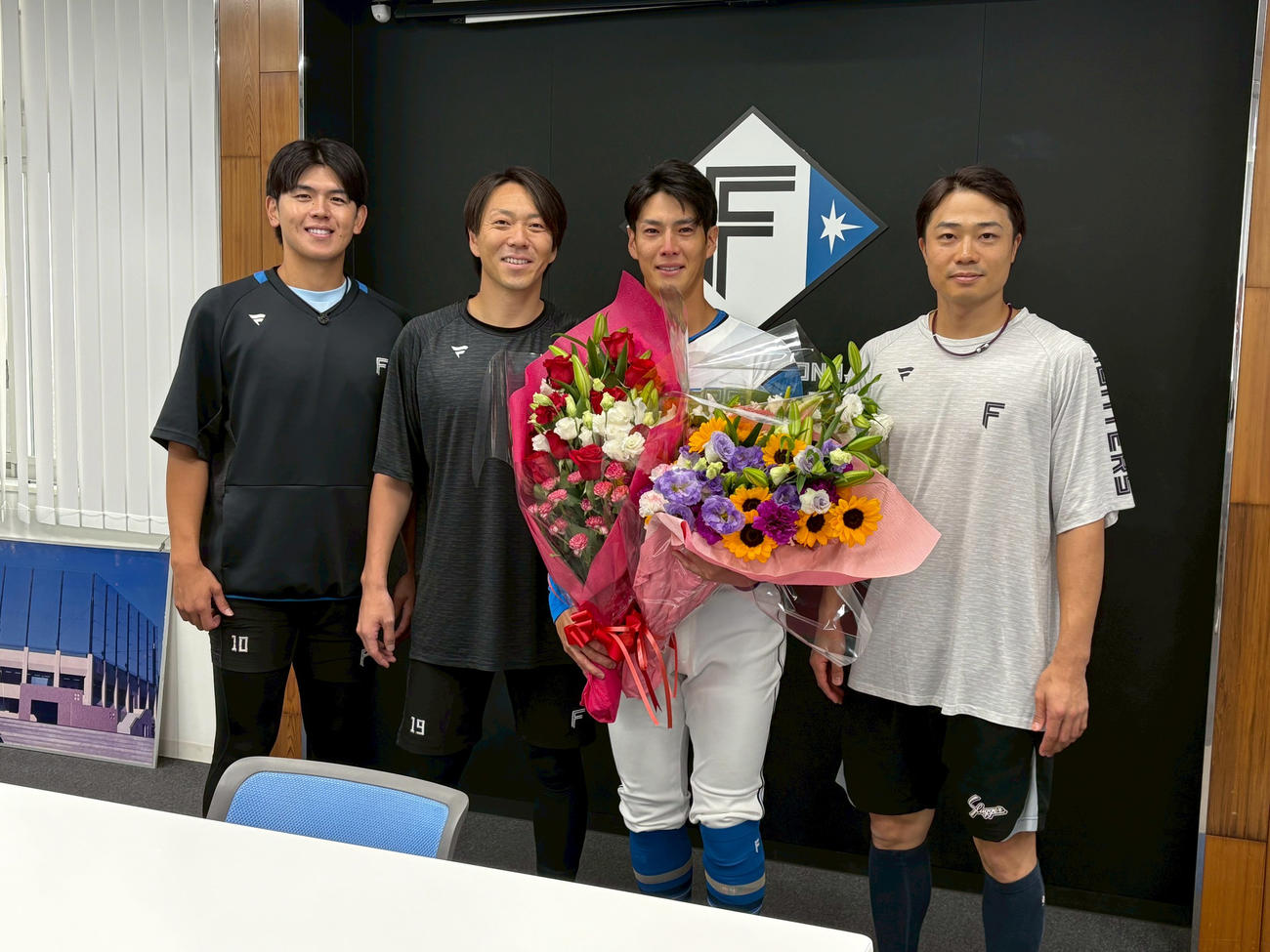 チームメートの左から清水優、宮西、中島から花束を贈られ笑顔