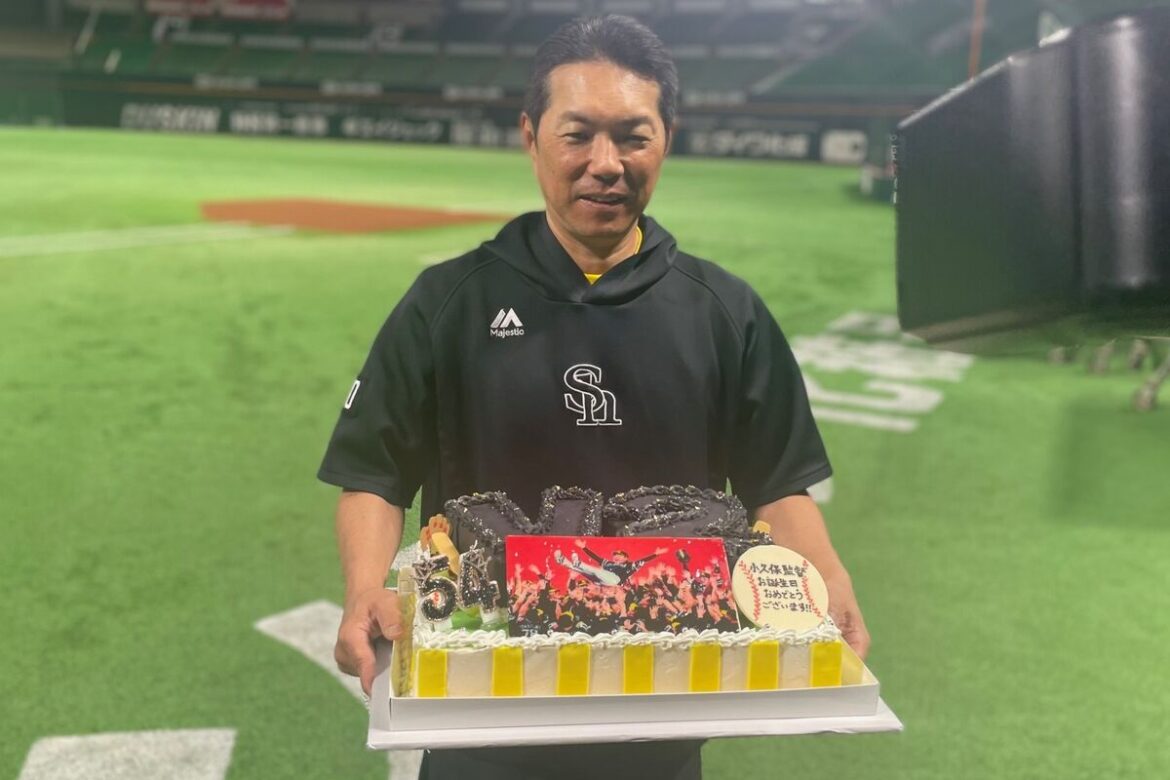 Manager Kokubo holding a birthday cake presented to him by the press