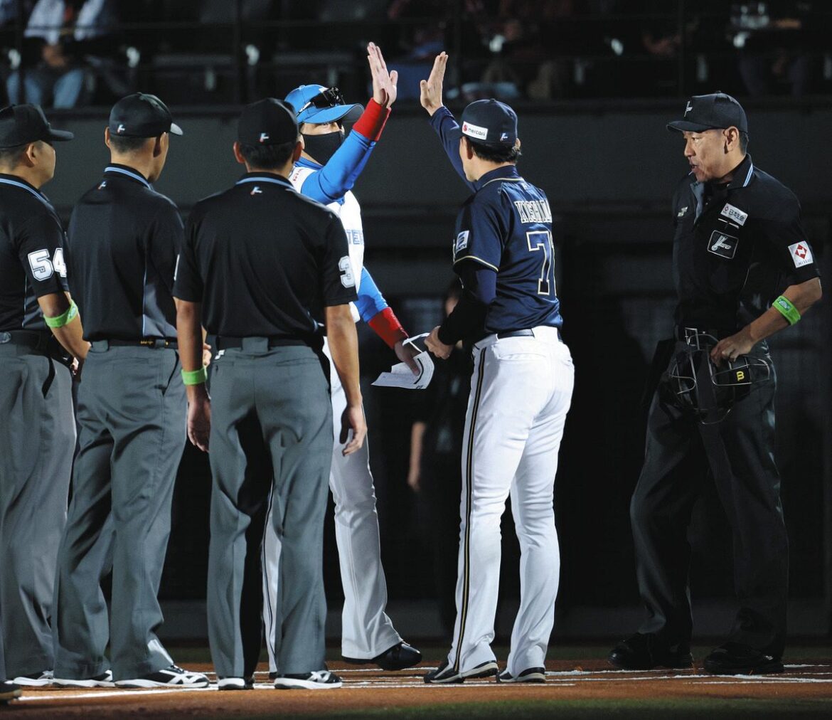 試合前のメンバー表交換でタッチを交わす日本ハム・新庄監督（左）とオリックス・岸田監督