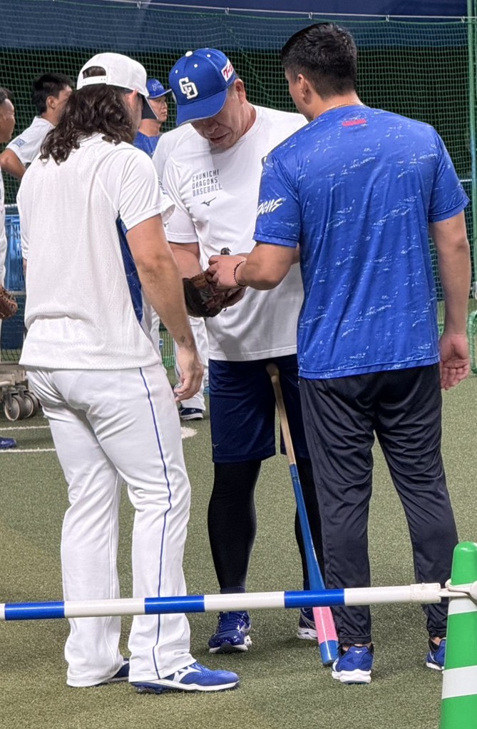 7月25日、井上監督（中央）はチェイビス（左）のグラブに興味津々。右は児玉通訳