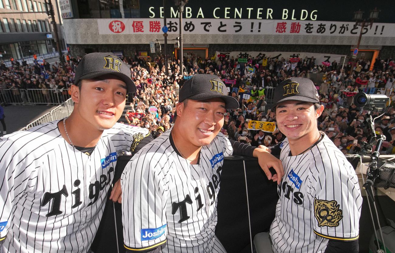 11月22日、優勝パレードで大勢のファンをバックに笑顔をみせる(左から)小幡、大山、中野(代表撮影)