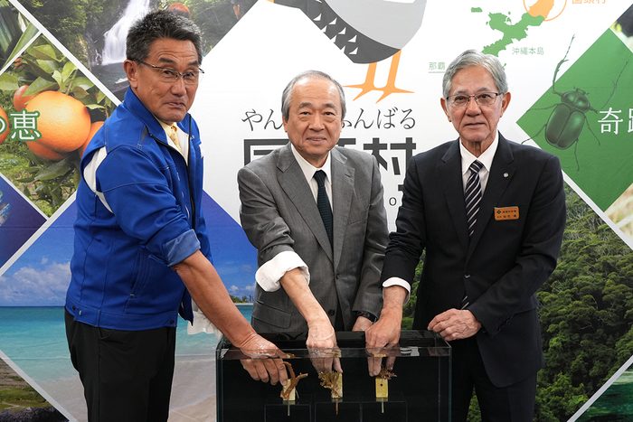 包括連携協定締結を記念しサンゴを植え付ける（左から）国頭村漁協の村田佳久組合長とよみうりランドの溝口烈社長、同村の知花靖村長＝27日、国頭村役場