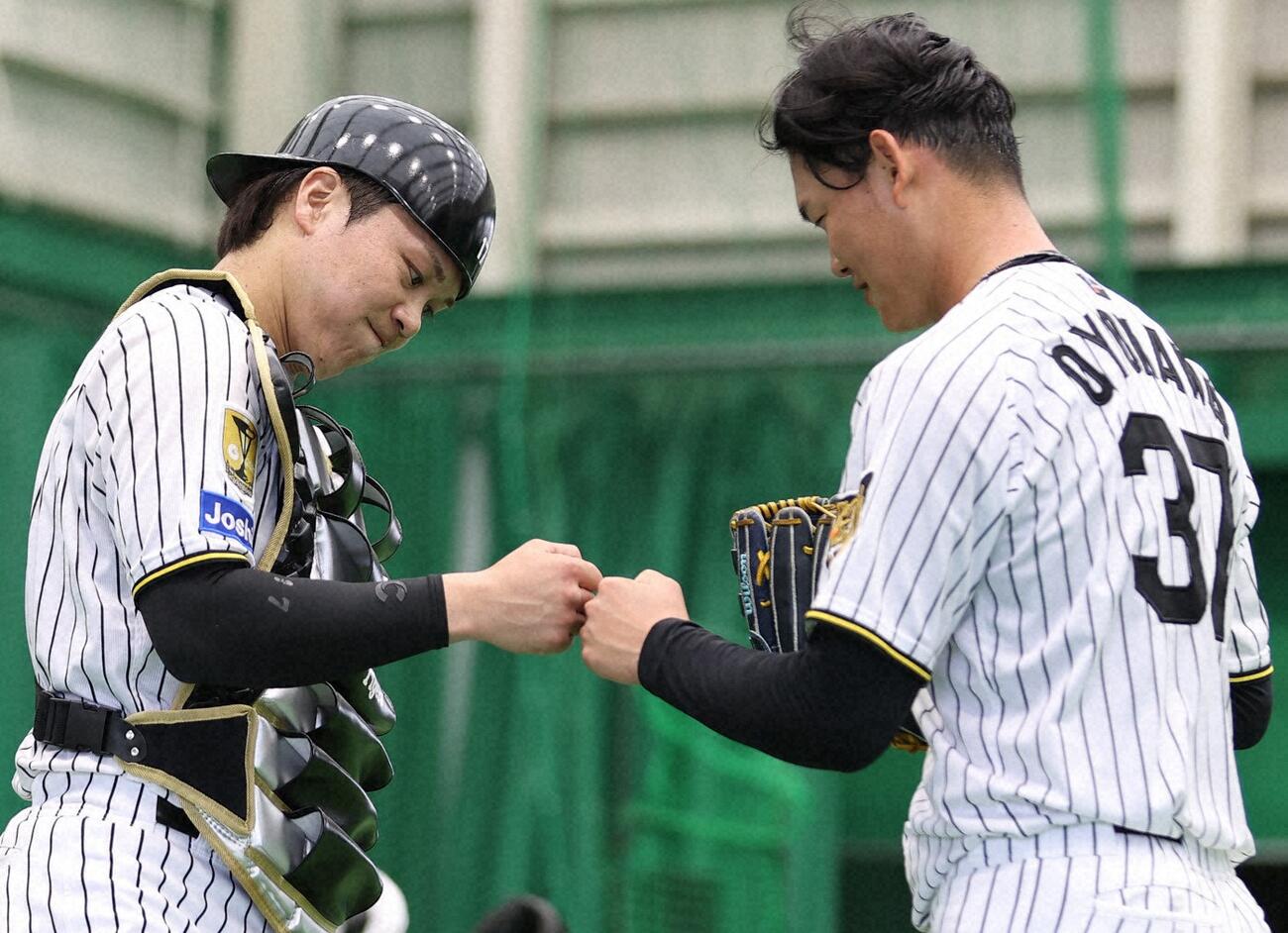 2月6日、ブルペン投球を終えた及川とグータッチ