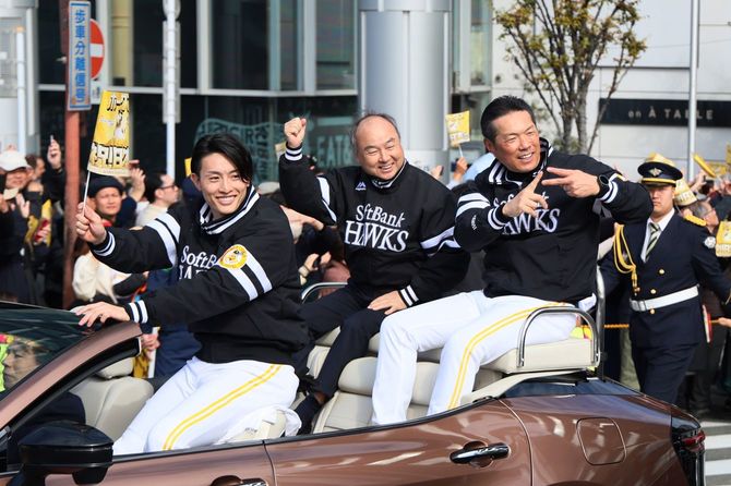 優勝パレードで、沿道のファンの歓声に応えるソフトバンクの（左から）周東佑京選手、孫正義オーナー、小久保裕紀監督＝2025年11月24日、福岡市内