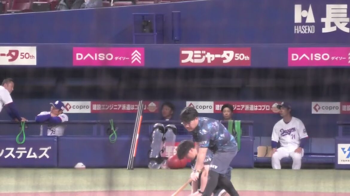 中日ドラゴンズ 平田良介コーチ・堂上直倫コーチがベンチで話している様子 選手がウォーミングアップのため姿を見せる