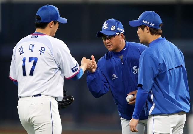 2019シーズン、金デウ（左）と会話を交わしている落合コーチ（中央）。 /写真=三星ライオンズ